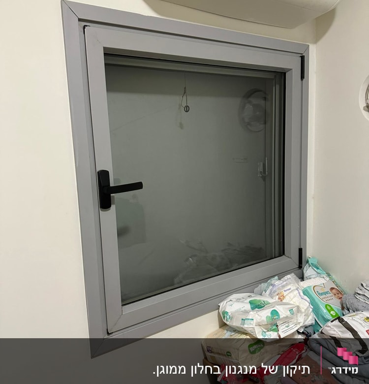 חלון עם תריסים סגורים ומסגרת אפורה